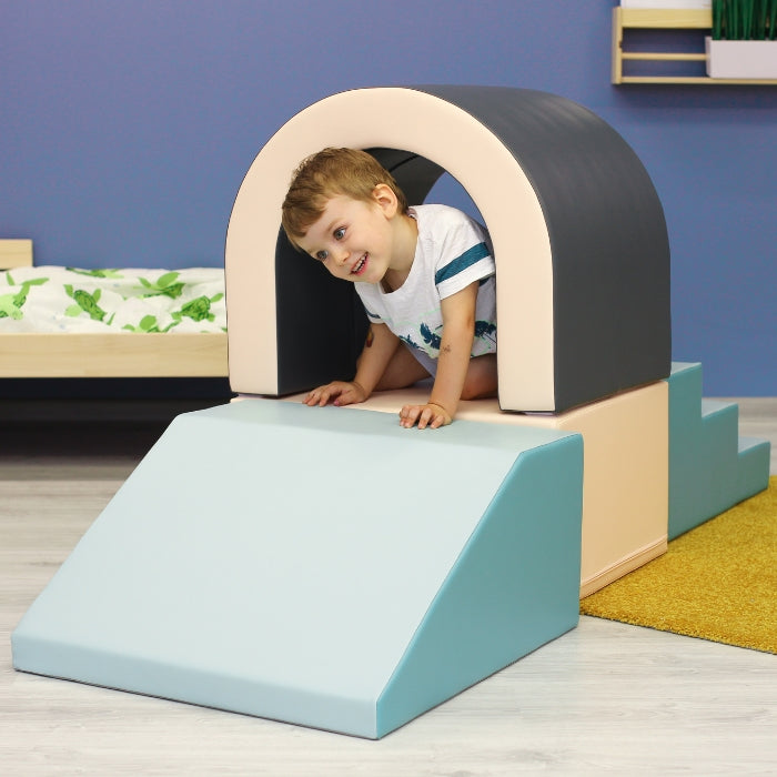 A boy playing with a soft play set