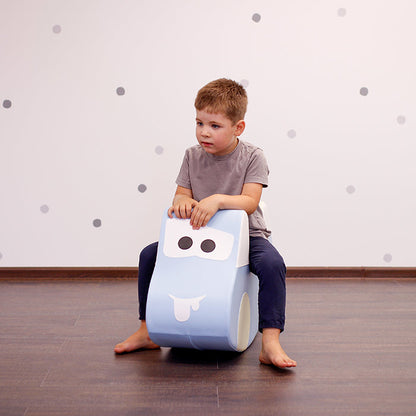 A boy sitting on a car foam rocking toy