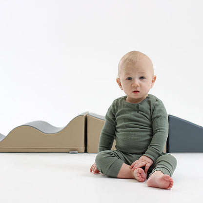 A baby sits on a Soft Play Set - Wave Venture, made by IGLU Soft Play, in front of a set of blocks.