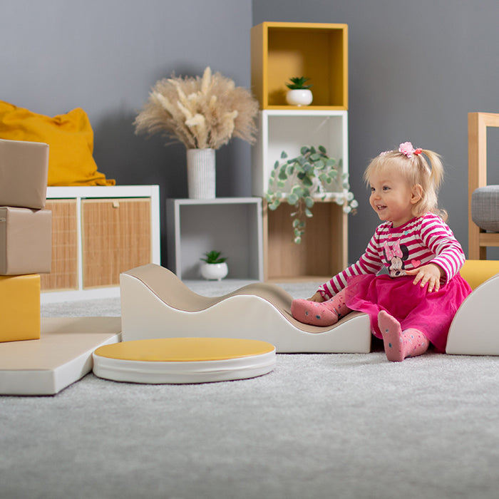 A little girl is playing with an IGLU Soft Play Soft Play Set - Pathfinder in a room.