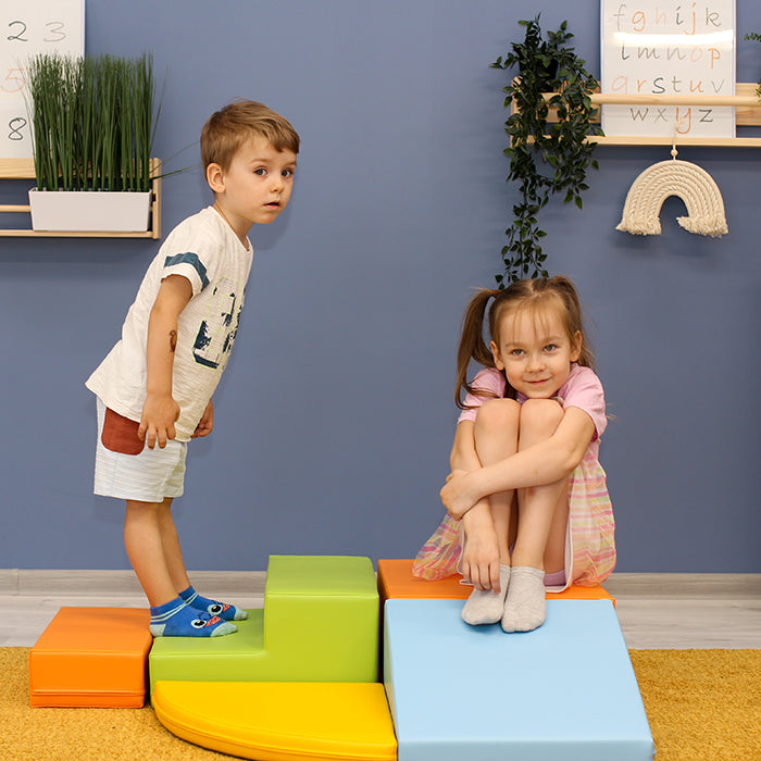 A boy and a girl playing with a colorful IGLU set