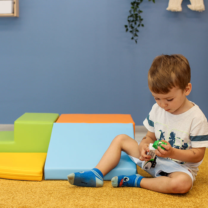 A boy playing next to an IGLU set